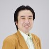 Headshot of Eiji Yanagisawa wearing a light orange jacket and white shirt and smiling