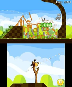 The White Angry Bird loads itself into a slingshot while another bird on the top screen careens into some wooden stacks, crushing some Green Pigs.